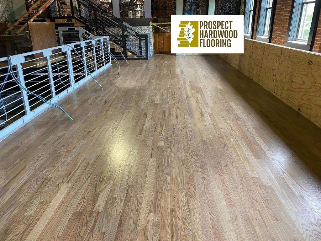 Freshly refinished red oak flooring in a Maryland commercial loft space with steel railings